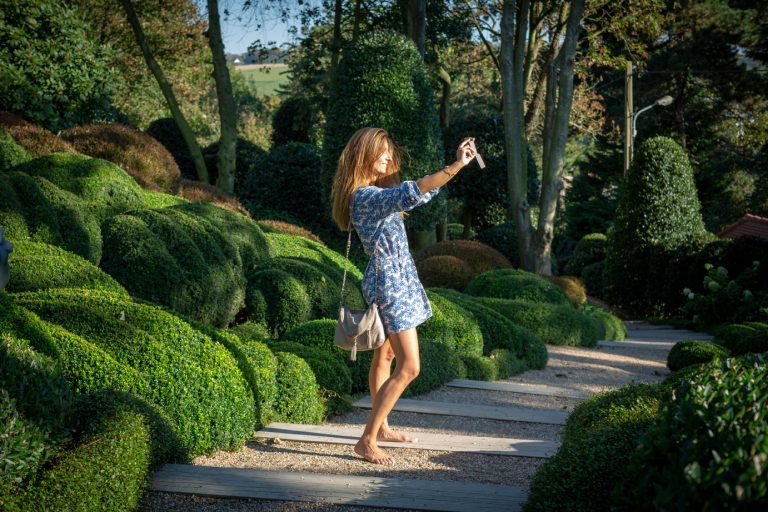 Une femme prend une photo dans les Jardins d'Etretat