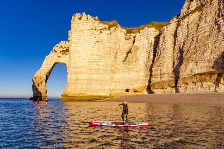 Un enfant en paddle le long des falaises d'Etretat