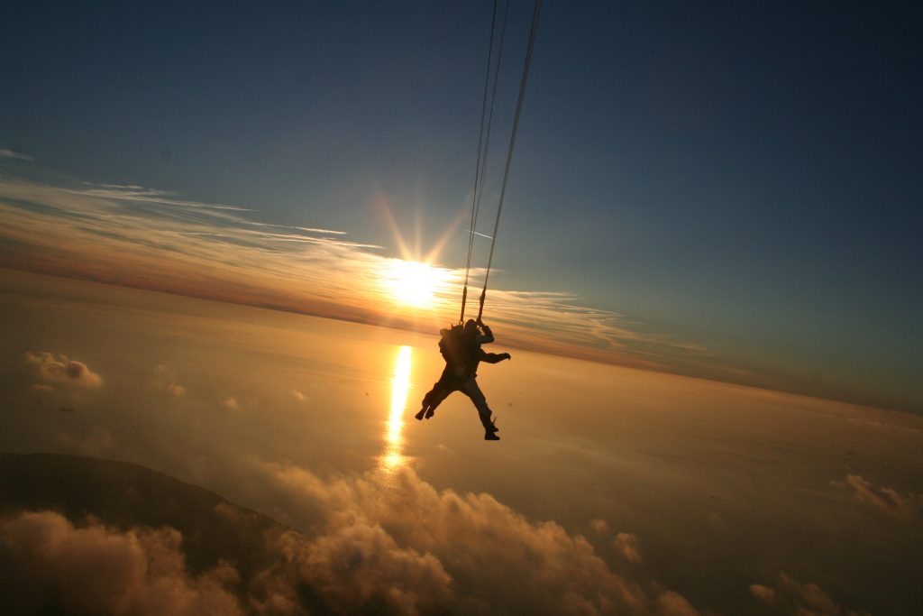 Saut en parachute avec le coucher de soleil