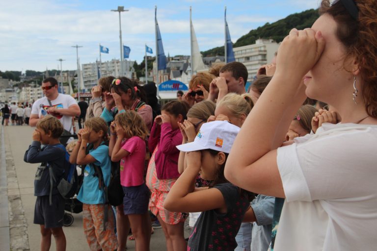 Groupe de plusieurs famille regardant vers la mer, devant les restaurants de la plage