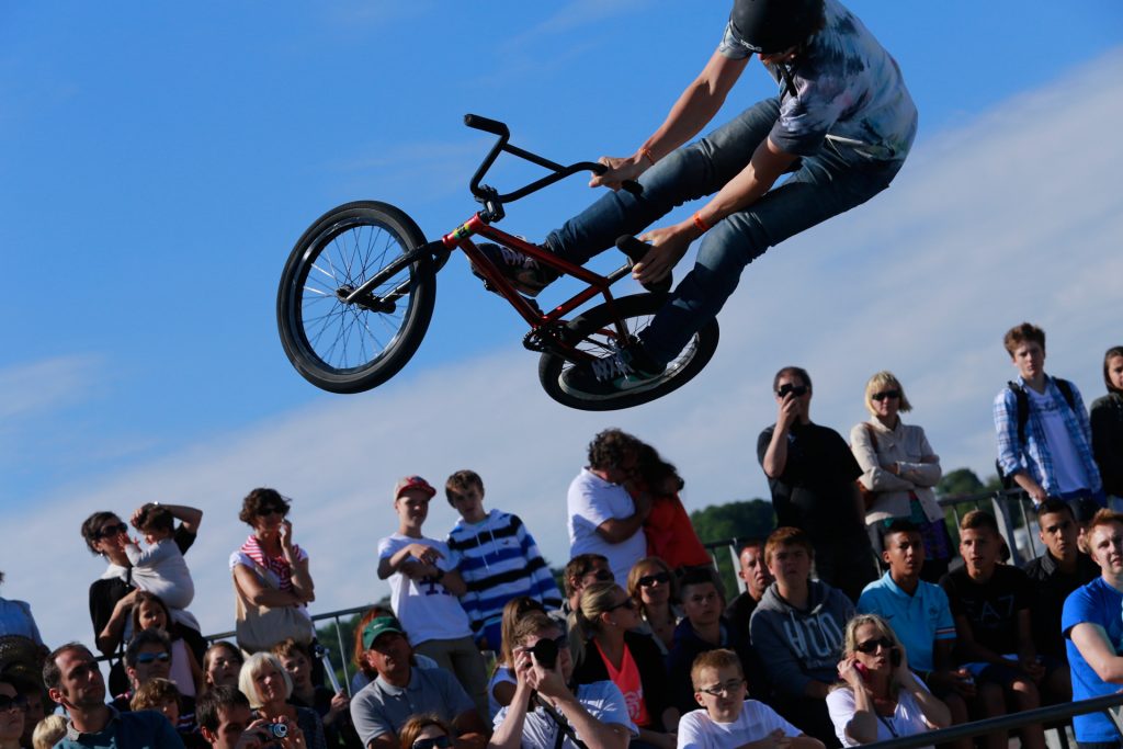 Figure acrobatique en BMX devant un public jeune