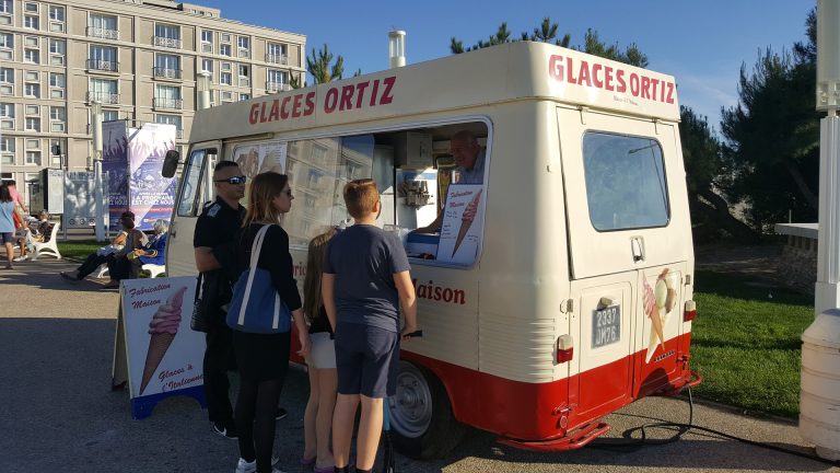 Promeneur à la plage achetant une glace au camion Ortiz