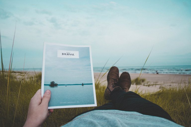 Homme sur la plage tenant une brochure