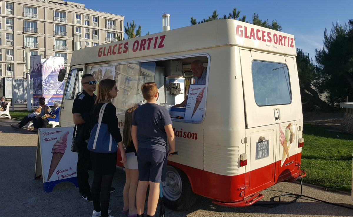 Promeneur à la plage achetant une glace au camion Ortiz